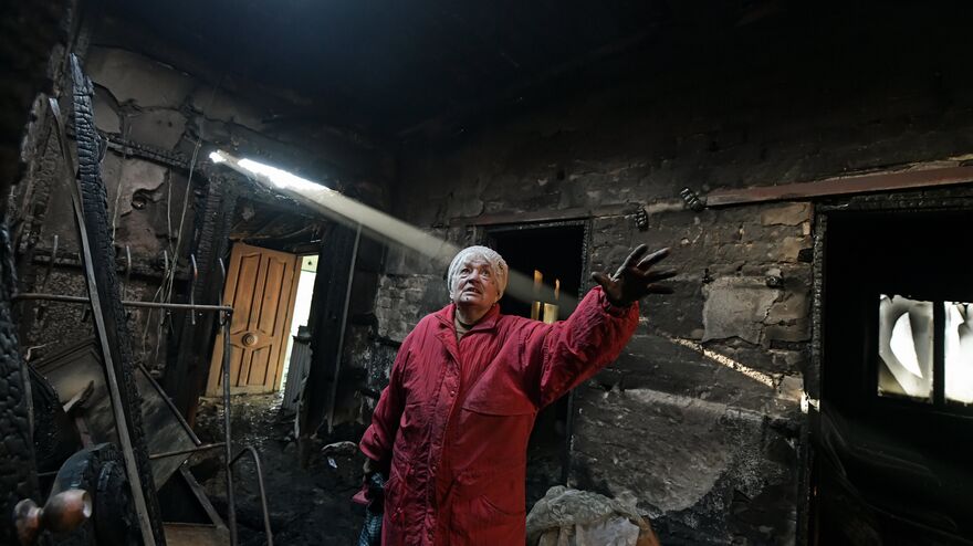 Женщина в сгоревшем доме после обстрела