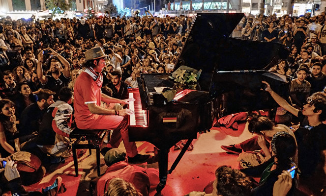 Мужчина играет на пианино для протестующих на площади Таксим в Стамбуле.