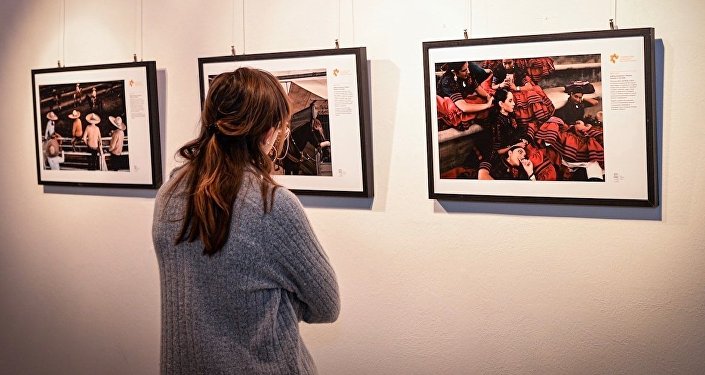 Посетительница на выставке победителей Международного конкурса фотожурналистики имени Андрея Стенина в художественной галерее Cascina Roma в Сан-Донато-Миланезе. Открытие выставки победителей конкурса им. А. Стенина в Италии