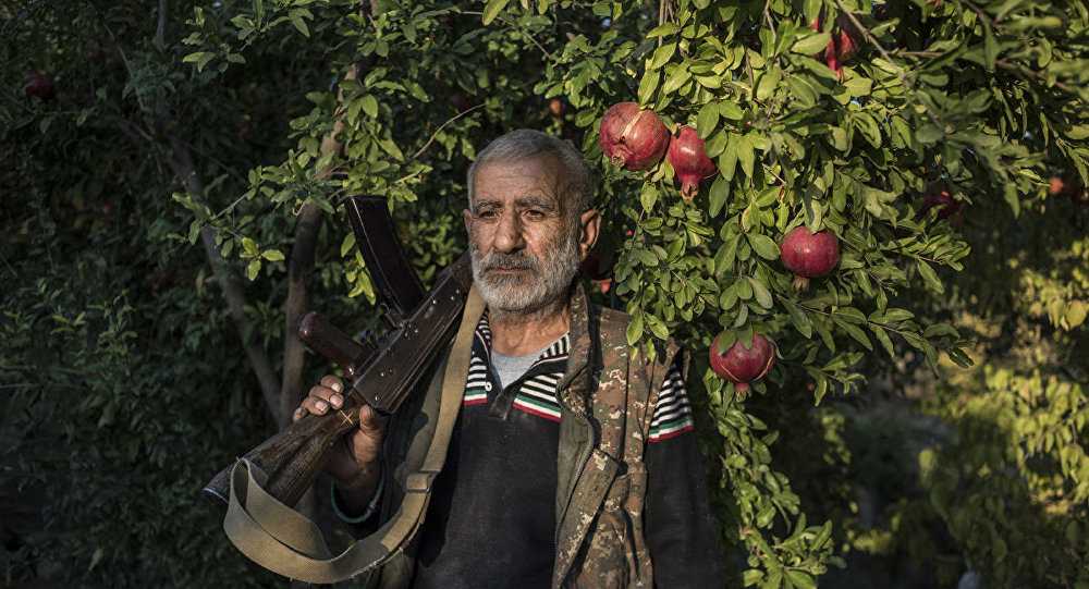 Paradise Lost A local resident Anushavan (62) stands in a pomegranate garden in the yard of his house. He is holding an old Kalashnikov assault rifle, which he has kept from the first Karabakh war. Ukhtasar village.