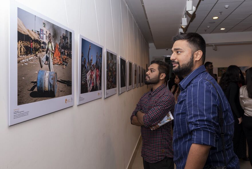 Посетители на выставке победителей Международного конкурса фотожурналистики имени Андрея Стенина в галерее AIFACS Gallery в Нью-Дели.