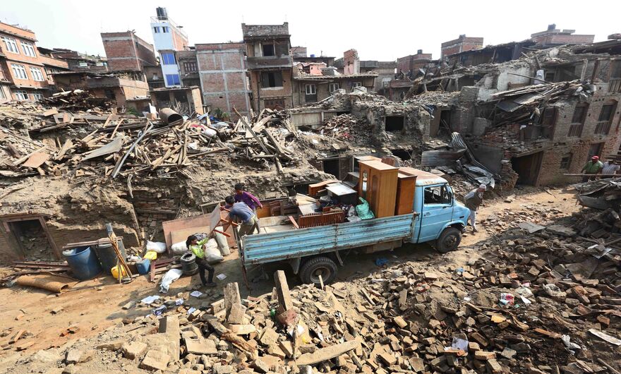 Люди, выжившие после землетрясения в Непале, пытаются спасти свои вещи из разрушенных домов в округе Бхактапур на окраине Катманду, Непал, 18 мая 2015года. Общее количество жертв землетрясения в 7,3 балла, случившегося 12 мая, составило 117 человек, помимо 8202 жертв землетрясения 25 апреля.