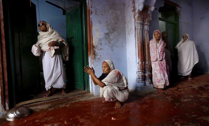 Пожилые вдовы наблюдают, как другие празднуют фестиваль Холи в городе Вриндаван, штат Уттар-Прадеш, Индия. Женщины впервые отпраздновали Холи в храме, так как во многих районах Индии вдовам до сих пор запрещено участвовать в этом и других фестивалях.